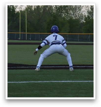 A baseball player is crouching on the field. Description generated by AI
