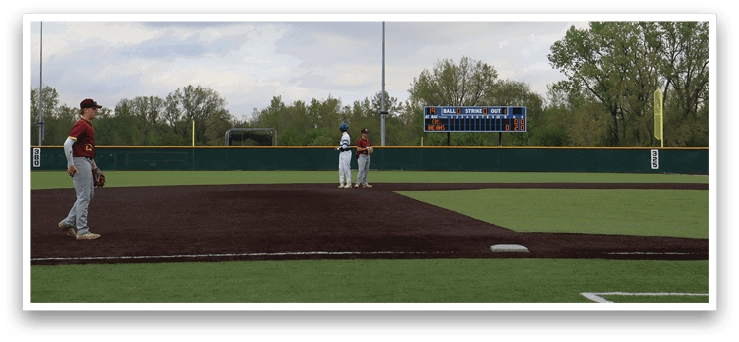 A baseball field with a man standing on the pitcher's mound. Description generated by AI