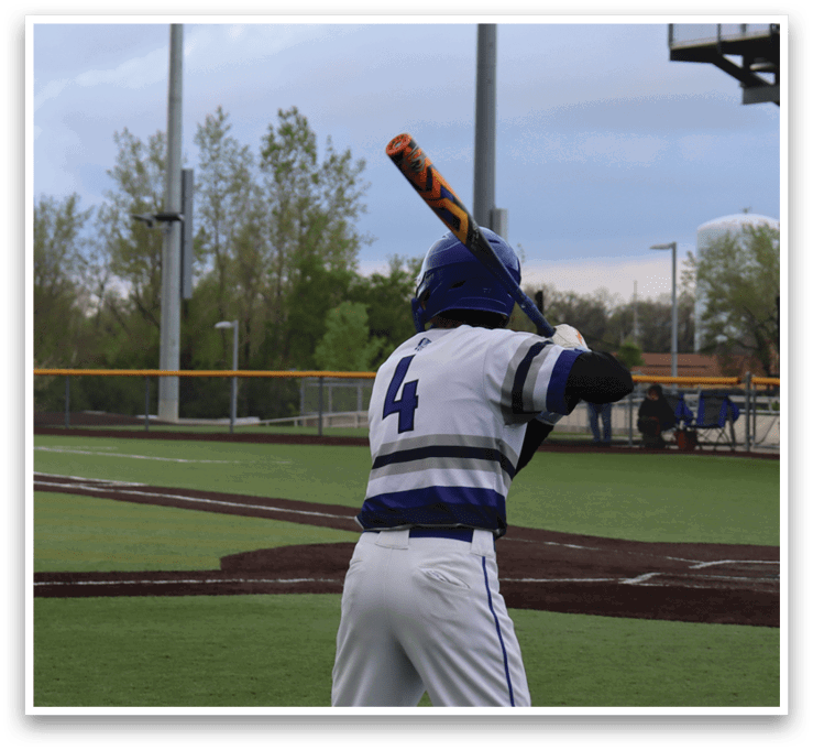 A baseball player is at bat, holding a bat and waiting for the pitch. Description generated by AI