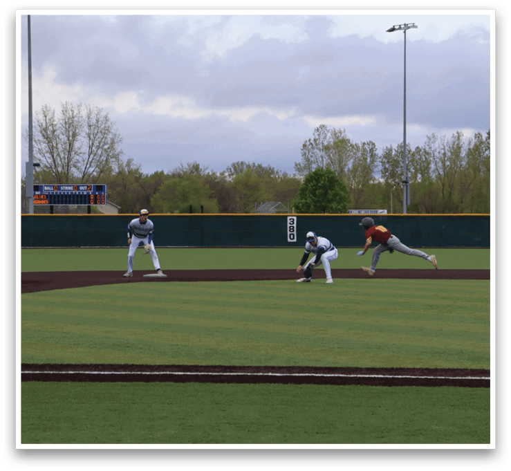 A baseball game is taking place on a field with a green grass. Description generated by AI