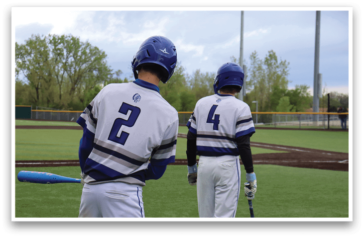 Two baseball players standing on a field. Description generated by AI