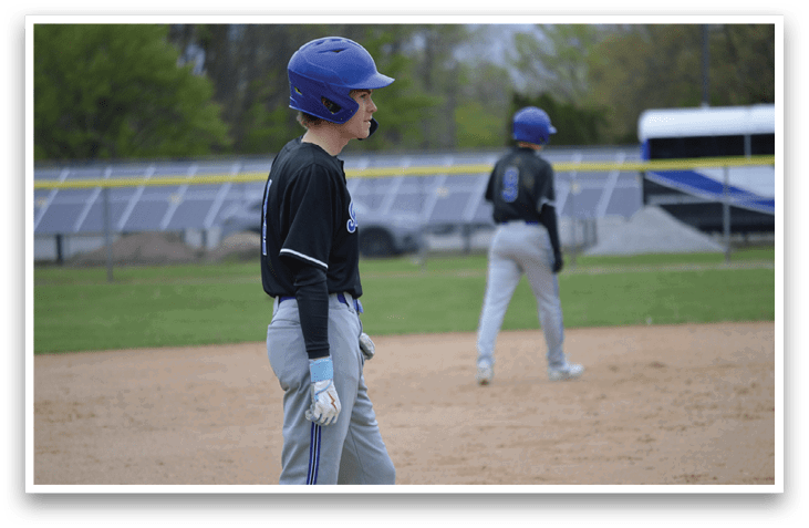 A baseball player wearing a blue helmet and a black shirt. Description generated by AI
