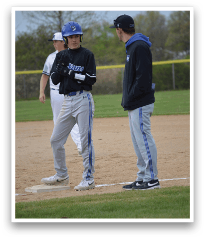 A baseball player wearing a blue jacket. Description generated by AI