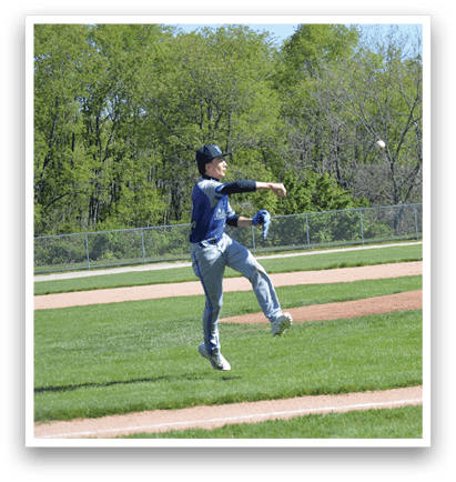 A baseball player in a blue shirt and grey pants is throwing a ball. Description generated by AI