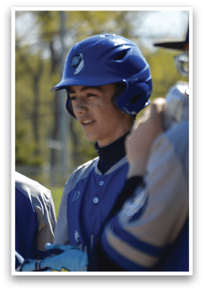 A boy wearing a blue helmet and blue and white baseball uniform. Description generated by AI