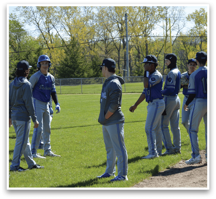 A group of baseball players standing on a field. Description generated by AI