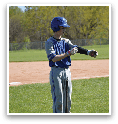 A boy wearing a blue helmet and a grey shirt is holding a baseball bat. Description generated by AI