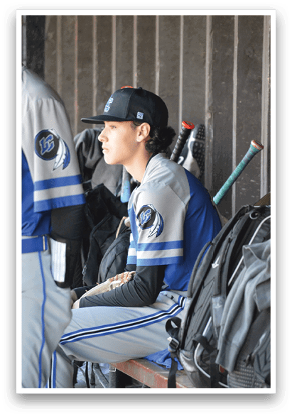 A person wearing a baseball uniform is laying on a bench. Description generated by AI