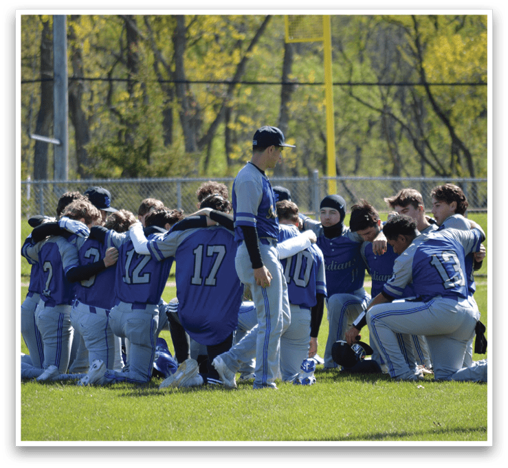 A group of baseball players huddled together on a field. Description generated by AI