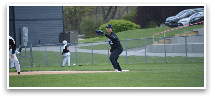 A baseball player in a black shirt and black pants is throwing a ball. Description generated by AI