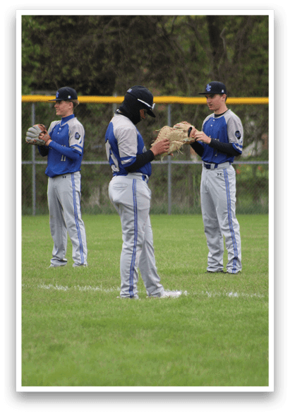 Three baseball players standing on a field. Description generated by AI
