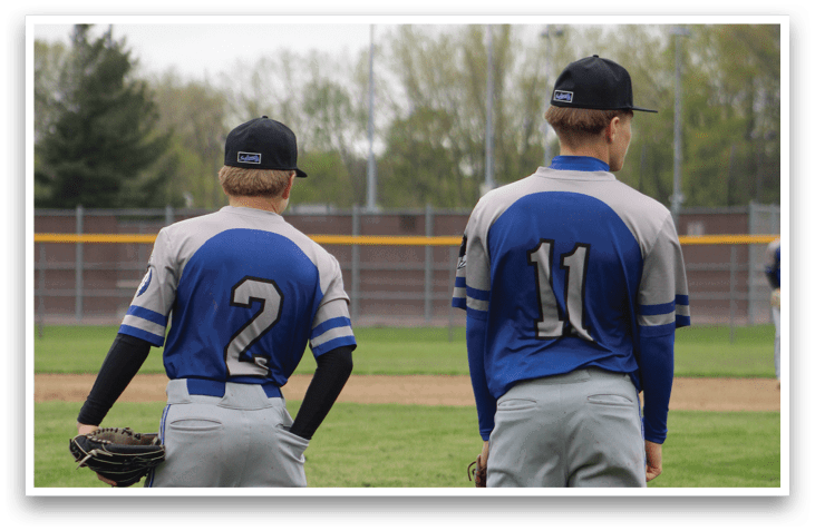 Two baseball players standing on a field. Description generated by AI