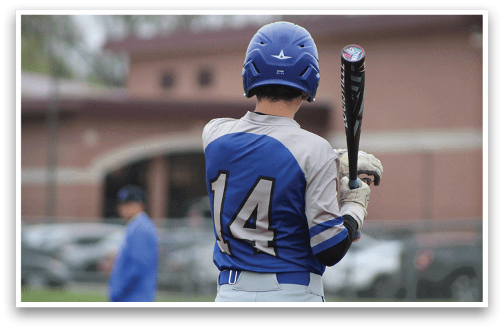 A baseball player wearing a blue and white uniform with the number 14 on the back. Description generated by AI