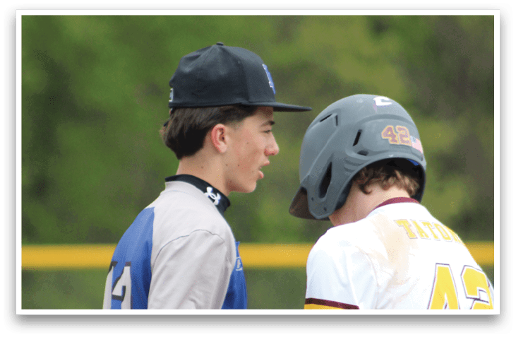 Two baseball players wearing blue and red uniforms. Description generated by AI