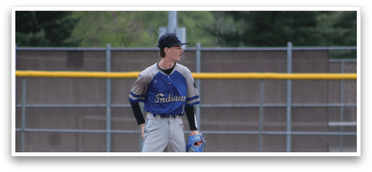 A baseball player in a blue and grey uniform standing on the field. Description generated by AI
