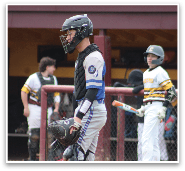 A baseball player wearing a helmet and catcher's gear. Description generated by AI