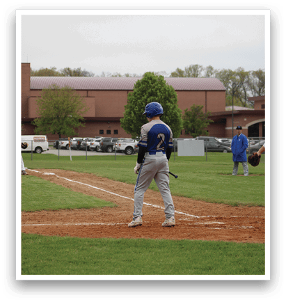 A baseball player is at bat, holding a bat and standing on the field. Description generated by AI