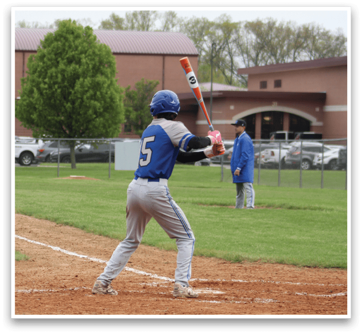 A baseball player is holding a bat and getting ready to hit a ball. Description generated by AI