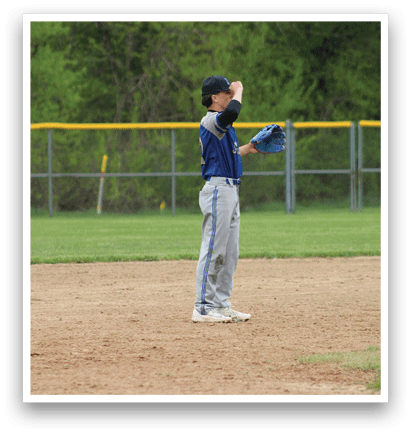 A baseball player wearing a blue shirt and a blue glove. Description generated by AI