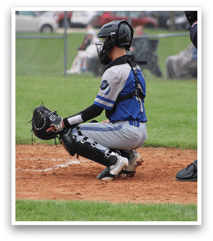 A baseball catcher is sitting on the ground with his glove on. Description generated by AI