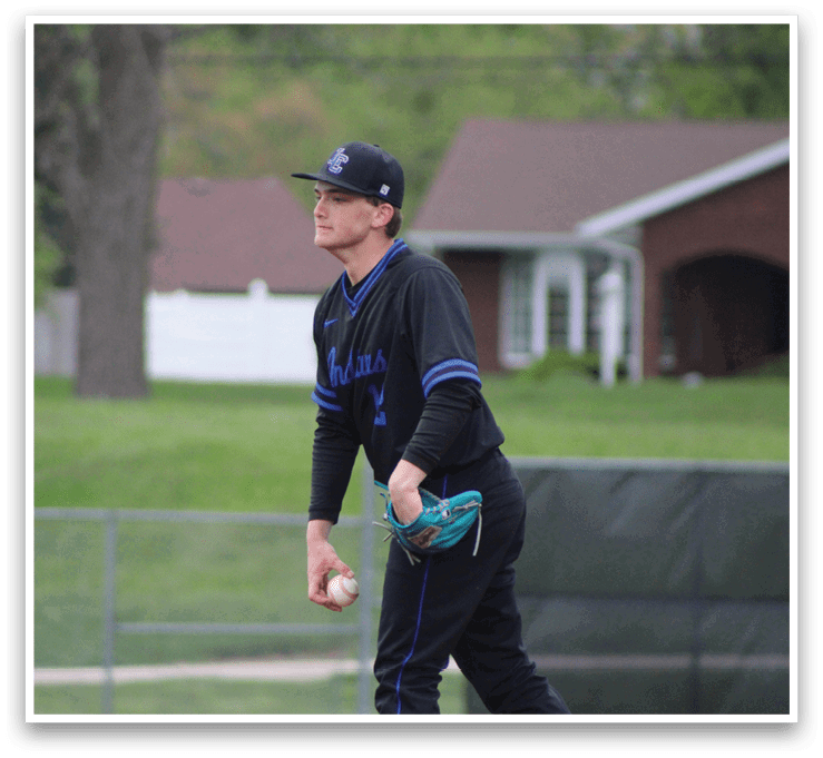 A baseball player in a black and blue uniform is throwing a ball. Description generated by AI