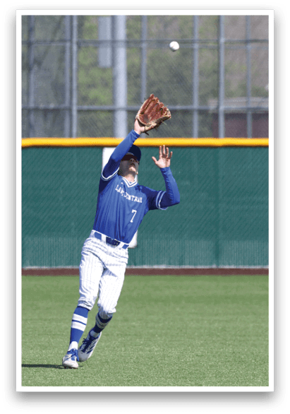 A baseball player in a blue and white uniform catching a ball. Description generated by AI
