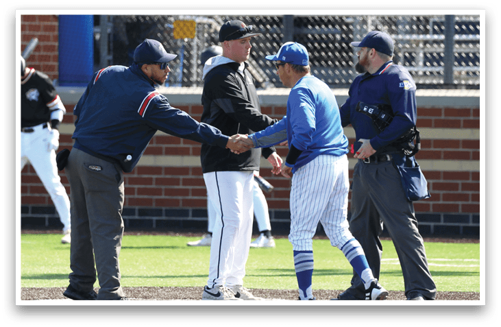 A baseball player wearing a blue shirt and white pants shakes hands with another player. Description generated by AI