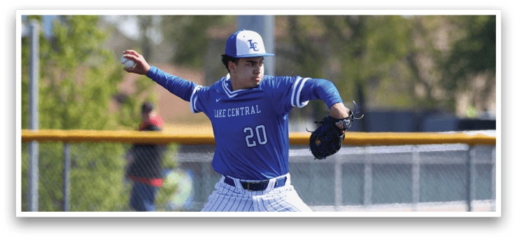 A baseball player in a blue and white uniform is pitching a ball. Description generated by AI