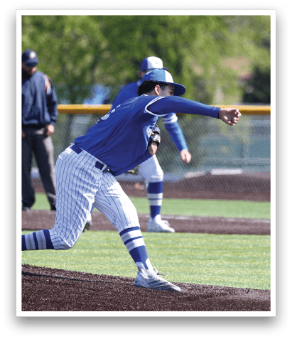 A baseball player in a blue and white uniform is pitching a ball. Description generated by AI