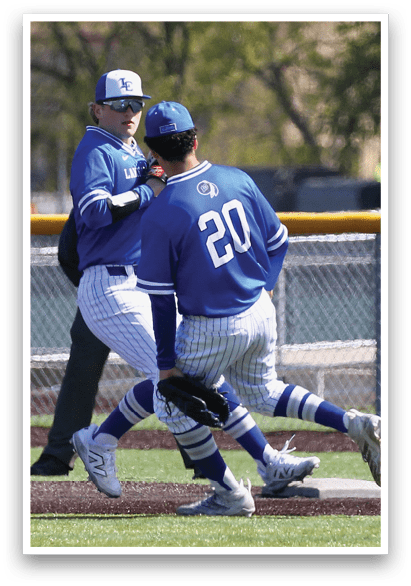 Two baseball players wearing blue uniforms. Description generated by AI