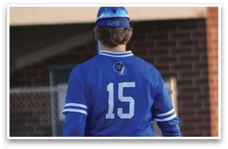 A baseball player wearing a blue shirt and white pants. Description generated by AI