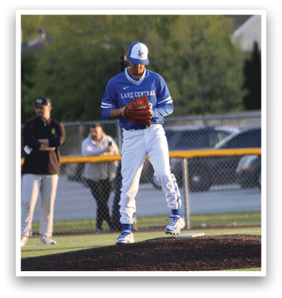 A baseball player in a blue and white uniform is standing on the pitcher's mound. Description generated by AI