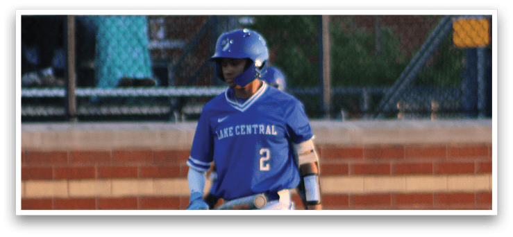 A baseball player is holding a bat and standing on a field. Description generated by AI