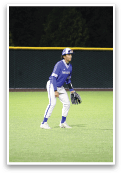 A baseball player wearing a blue and white uniform. Description generated by AI