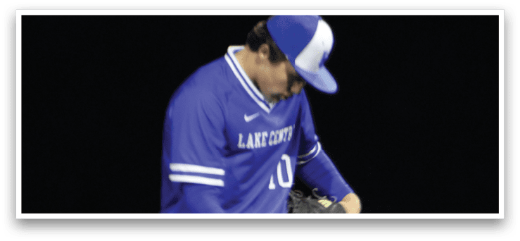 A baseball player bending over to catch a ball. Description generated by AI