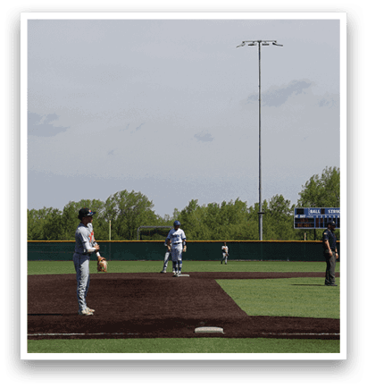 A baseball player is standing on a field with a baseball glove. Description generated by AI