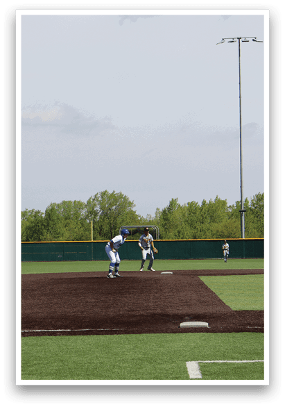 A baseball game is taking place on a field with a man standing in the dirt. Description generated by AI