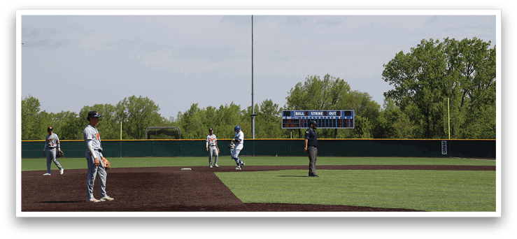 A baseball field with a man standing in the outfield. Description generated by AI