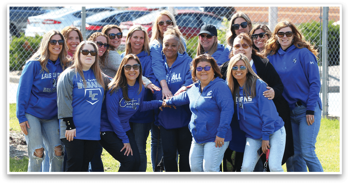 A group of women wearing blue shirts and sunglasses. Description generated by AI