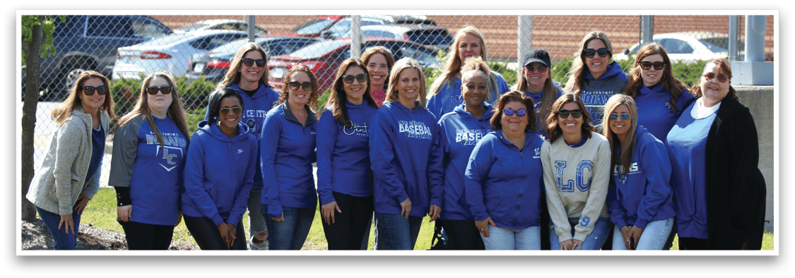 A group of women wearing blue shirts and jeans. Description generated by AI