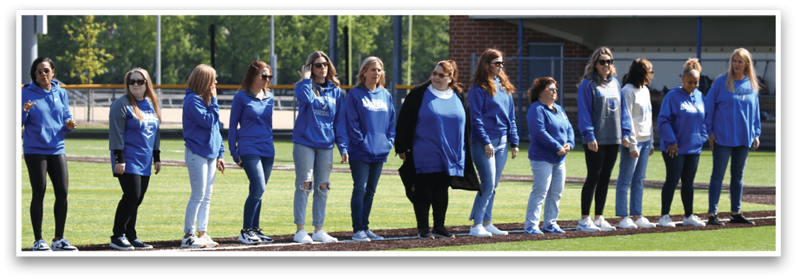 A group of women wearing blue shirts and white shoes. Description generated by AI