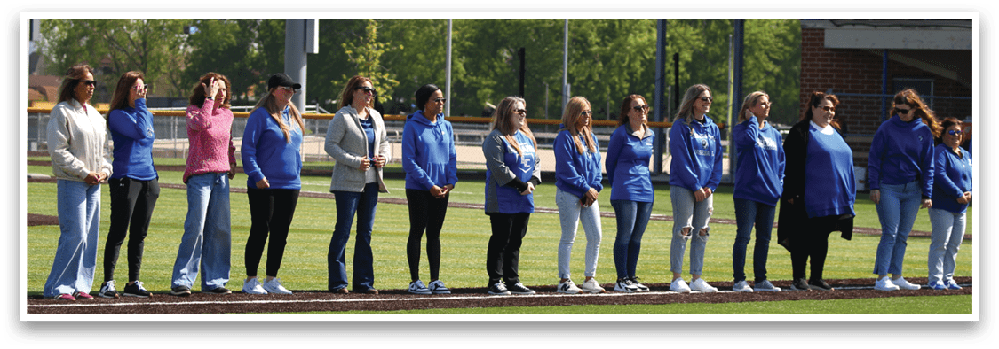 A group of women wearing blue shirts and white shoes. Description generated by AI