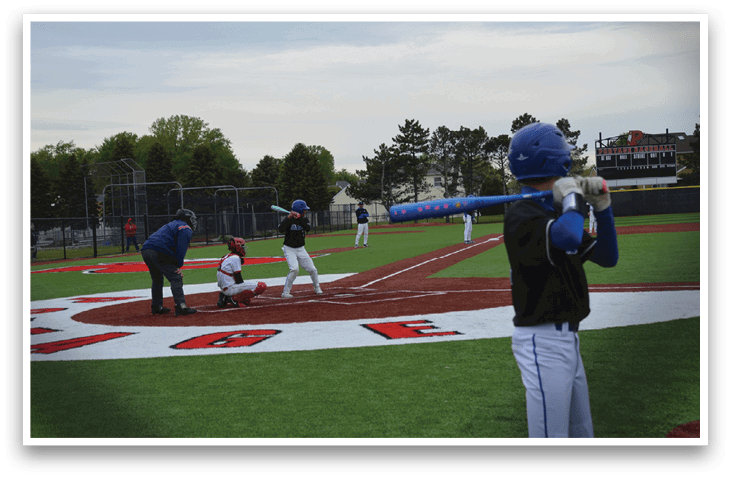 A boy is holding a bat and getting ready to hit a ball. Description generated by AI