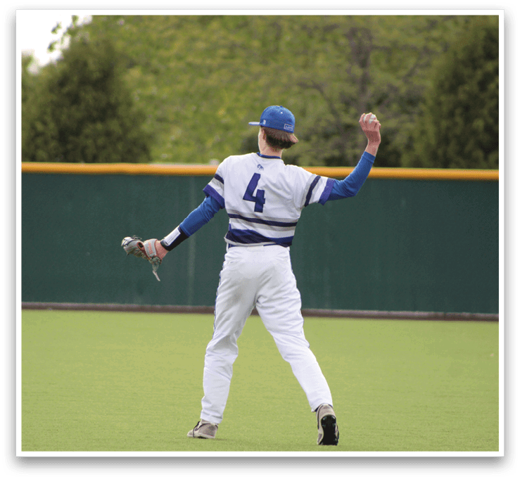 A man wearing a blue and white baseball uniform is holding a bat and standing on a baseball field. Description generated by AI