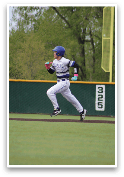 A baseball player wearing a blue helmet and white uniform is running towards a base. Description generated by AI