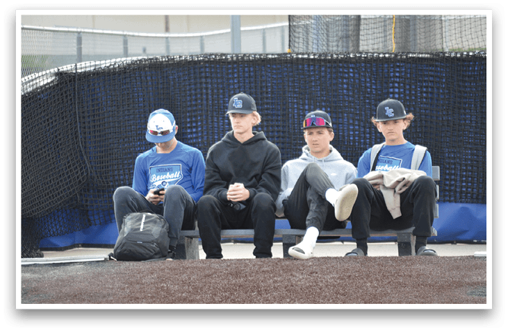 Four boys sitting on a bench. Description generated by AI