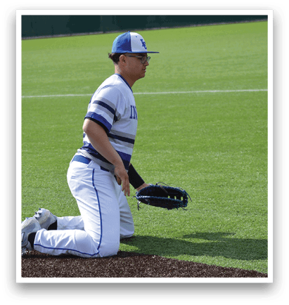 A baseball player kneeling on the ground with a glove on. Description generated by AI