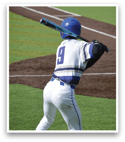 A baseball player in a blue helmet and white uniform is swinging a bat. Description generated by AI