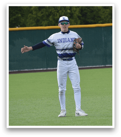 A man wearing a baseball uniform stands on a baseball field. Description generated by AI