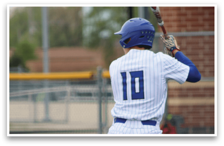 A baseball player in a white and blue uniform is holding a bat and getting ready to swing. Description generated by AI